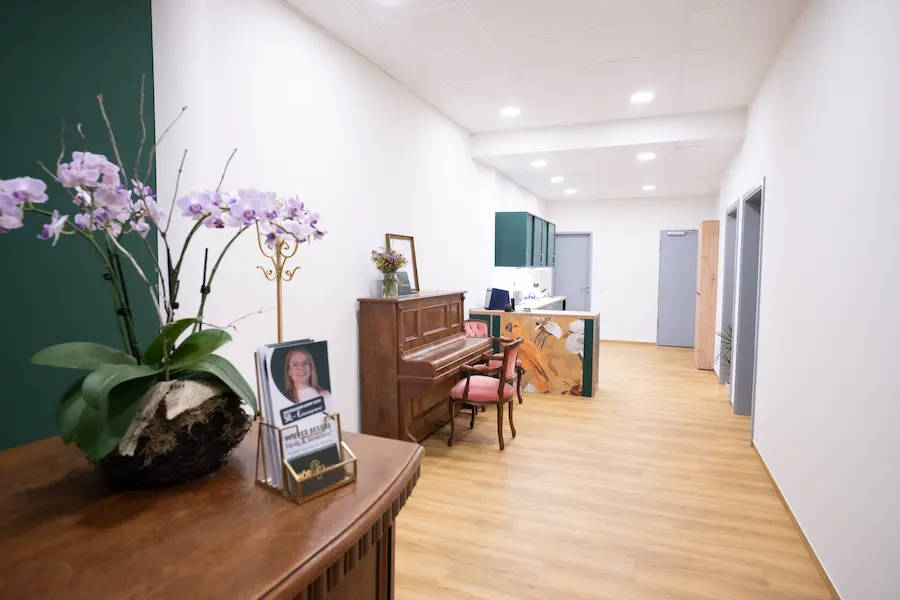 Innenraum des Fachgeschäfts HÖRGUTzmann mit Empfang, Blumenwand und Blick in die Werkstatt.