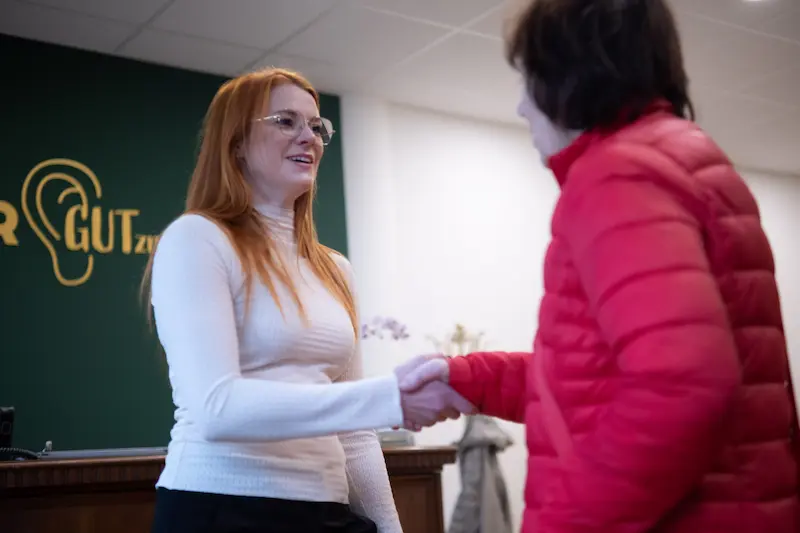 Jessica Gutzmann verabschiedet eine Kundin im Empfangsbereich des Fachgeschäfts HÖRGUTzmann in Schwerin.